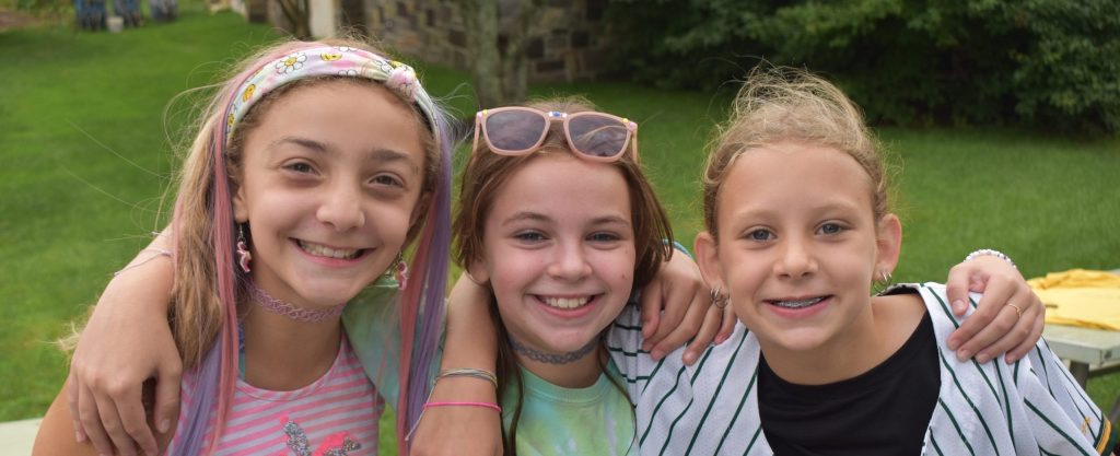 three young girls in a group during summer day camp programming